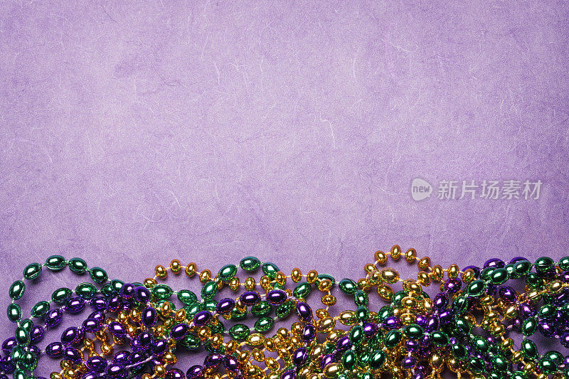 MMardi Gras Beads On A Purple Background